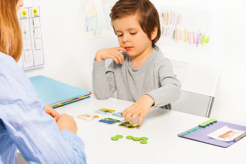 A young child matching picture cards during an ABA therapy session